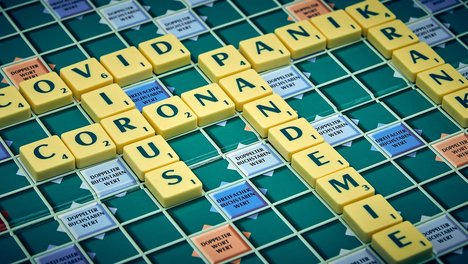 Das Foto zeigt ein Scrabble-Brett, auf dem verschiedene Begriffe der Corona-Pandemie gelegt sind. 